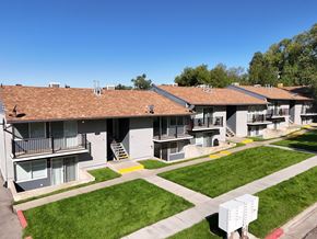 Ogden townhouse for rent - Apartment complex with green grass and trees in the background.