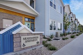Ogden apartment for rent - A sign for Meadowbrook Apartments is displayed in front of a building.