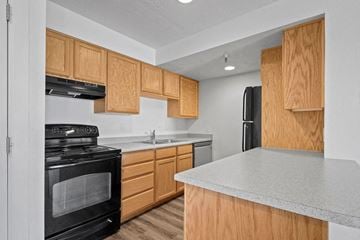 Park City condo for rent - A kitchen with wooden cabinets and a black stove top oven.