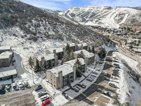 Park City condo for rent - A red car is parked in a parking lot in front of a building.