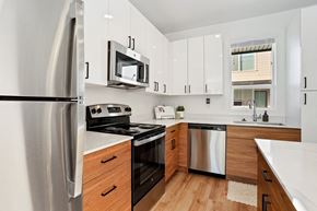Ogden townhouse for rent - a kitchen with white cabinets and stainless steel appliances at Greens by Lotus Townhomes, Ogden, UT, Utah , 84403