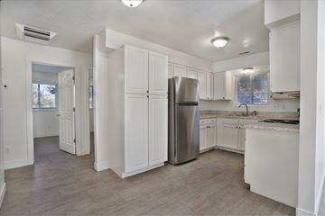 Ogden apartment for rent - A kitchen with white cabinets and a stainless steel refrigerator.