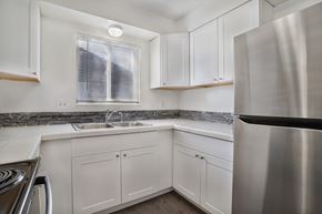 Ogden townhouse for rent - A modern kitchen with white cabinets and a stainless steel refrigerator.