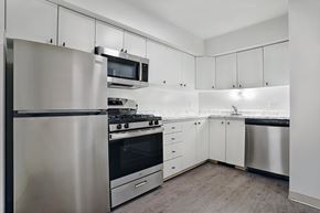 Ogden apartment for rent - A modern kitchen with stainless steel appliances and white cabinets.