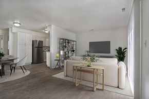 Ogden apartment for rent - A modern living room with a white sofa, a wooden coffee table, and a TV on the wall.