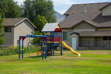 Logan apartment for rent - A playground with a red and blue structure and a yellow slide.