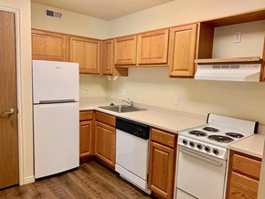 Bountiful apartment for rent - A kitchen with white appliances and wooden cabinets.