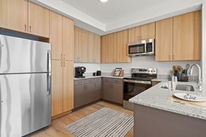 Salt Lake City apartment for rent - a kitchen with stainless steel appliances and wooden cabinets at SPARK Apartments, Salt Lake CIty, UT