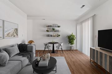Sandy apartment for rent - a living room with a gray couch and a table and a television