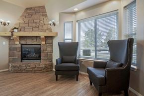 Logan apartment for rent - A living room with a stone fireplace and two leather chairs.