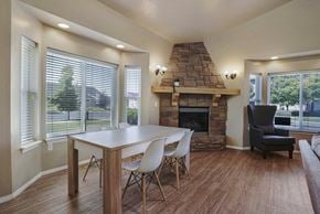 Logan apartment for rent - A dining room with a stone fireplace and a table set for four.
