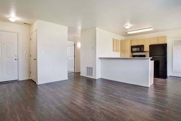 Logan apartment for rent - A kitchen area with a white counter and a black fridge.