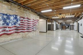 Logan apartment for rent - A large American flag painted on a brick wall in a spacious room.
