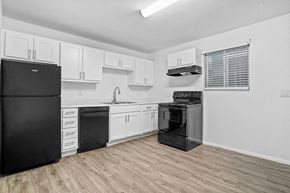 Midvale apartment for rent - a kitchen with white cabinets and black appliances