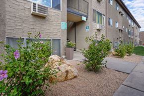 Midvale apartment for rent - an outside view of a building with flowers and a rock