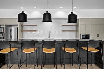 Salt Lake City apartment for rent - A modern kitchen with black chairs and a white backsplash.