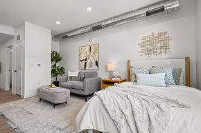 Salt Lake City apartment for rent - A bedroom with a large bed and a grey couch.