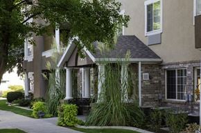 Bountiful apartment for rent - A house with a front porch and a tree in front.