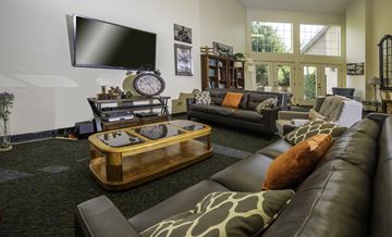 Bountiful apartment for rent - A living room with a large leather couch and a wooden coffee table.