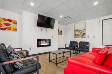 Salt Lake City apartment for rent - A living room with a red couch and a television mounted on the wall.