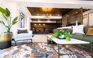 Ogden apartment for rent - A living room with a patterned rug and a white sofa.