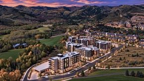 Park City townhouse for rent - A large building complex is surrounded by a grassy area and trees.