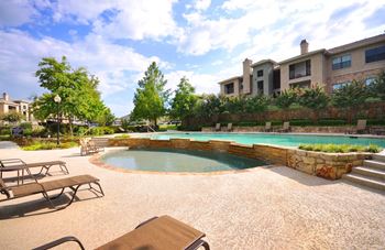 Multilevel swimming pool with stone accents and lounge seating