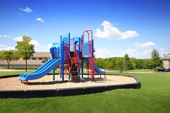 Playground with slides and climbing features on gravel surface