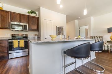 Tyler apartment for rent - A kitchen with a white counter top and black chairs.