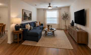 Tyler apartment for rent - A living room with a blue couch and a television on the wall.