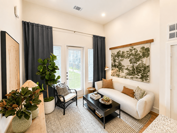 Kerrville apartment for rent - A living room with a white couch, a coffee table, and a painting on the wall.