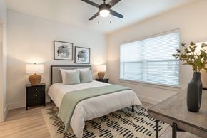Burleson apartment for rent - A bedroom with a bed, a ceiling fan, and a rug.