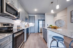 Little Elm apartment for rent - A modern kitchen with dark wood cabinets and stainless steel appliances.