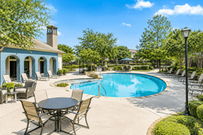 Balch Springs apartment for rent - A pool with a table and chairs in front of a blue house.