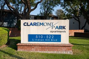 Claremont apartment for rent - A sign for Claremont Park Apartments is displayed in front of a building.