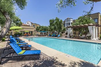 A swimming pool with blue and yellow lounge chairs