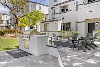 An outdoor patio with a grill and tables and chairs