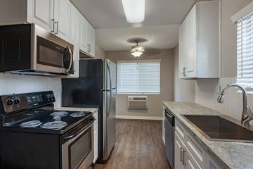 Poway apartment for rent - a kitchen with black appliances and white cabinets