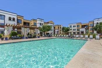 A swimming pool with apartments in the background