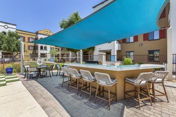 A patio with a bar and tables with chairs