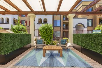 A patio with a table and chairs and a pool