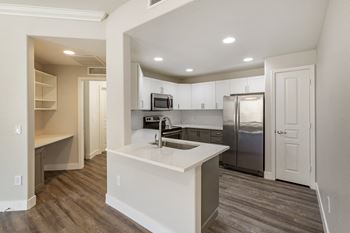 A kitchen with stainless steel appliances and a white counter top