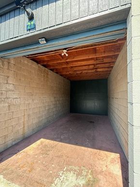 Poway apartment for rent - an empty garage with a brick wall and wood ceiling