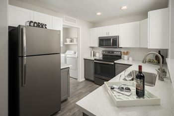 A kitchen with stainless steel appliances and white cabinets