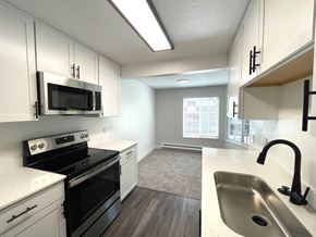 Kirkland apartment for rent - an empty kitchen with white cabinets and black appliances and a sink at Bridlewood, Washington, 98034