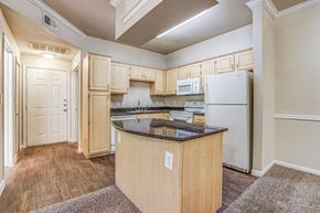 Frisco apartment for rent - Interior kitchen with wooden cabinetry, modern appliances, and granite counter top at Cypress Lake at Stonebriar Apartments, Texas, 75034