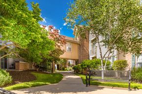 Lawrence apartment for rent - A residential area with a building and a tree at Prairie Commons - 55+ Senior Community Apartments, Lawrence, KS, 66049