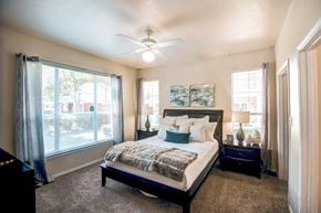 Dallas apartment for rent - A bedroom with a large bed and a piano.