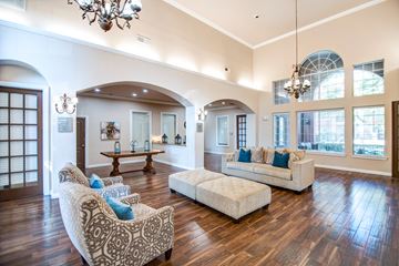 Dallas apartment for rent - A living room with a white couch and a patterned chair.