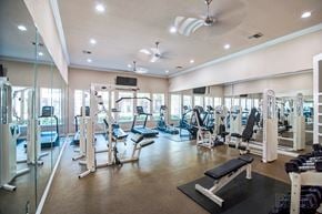 Dallas apartment for rent - A spacious gym with a variety of equipment and a ceiling fan.